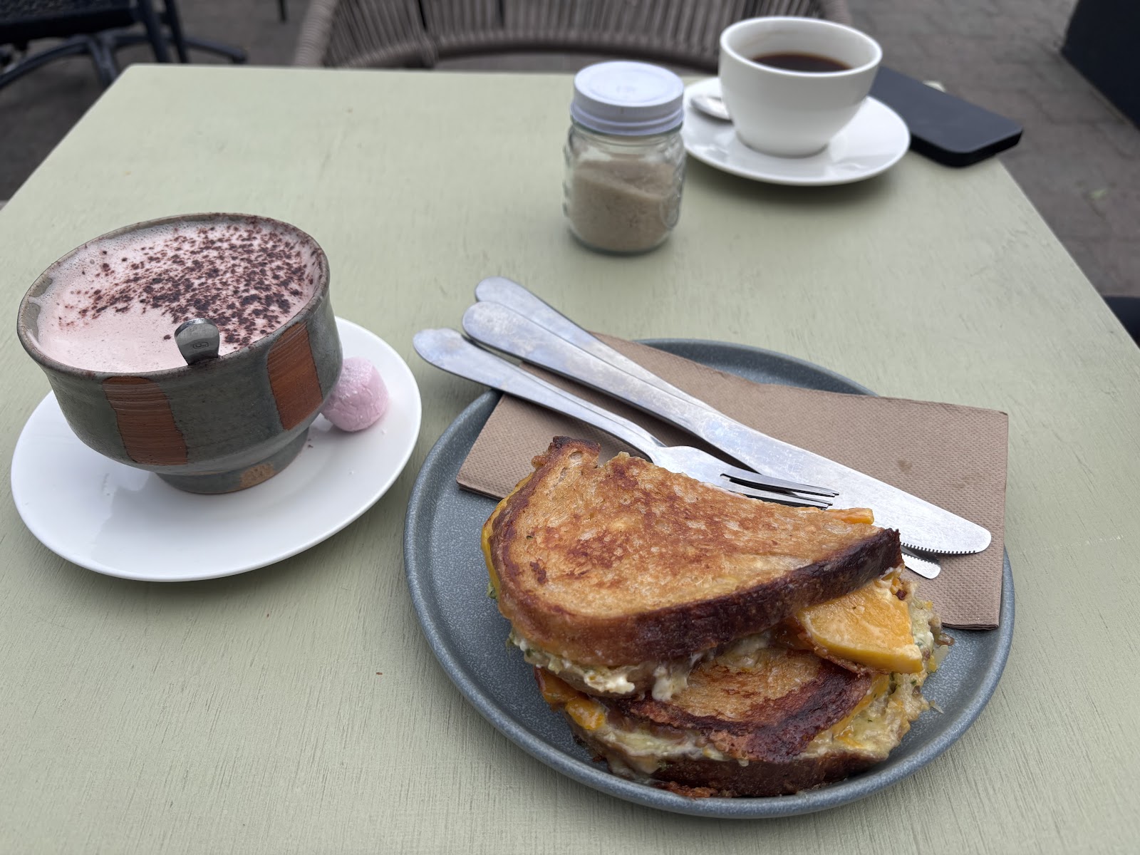 A toastie and hot chocolate on the outside table