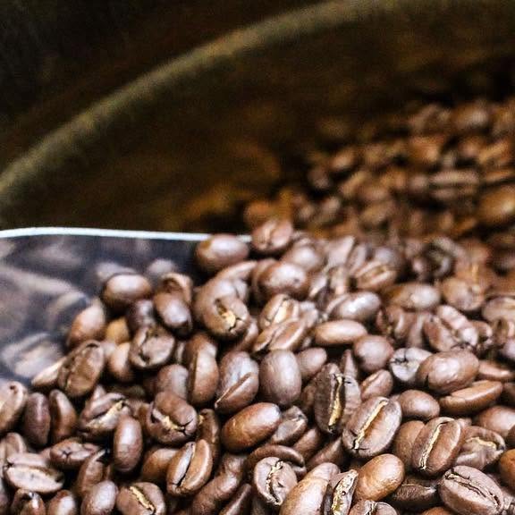 A scoop of roasted coffee beans