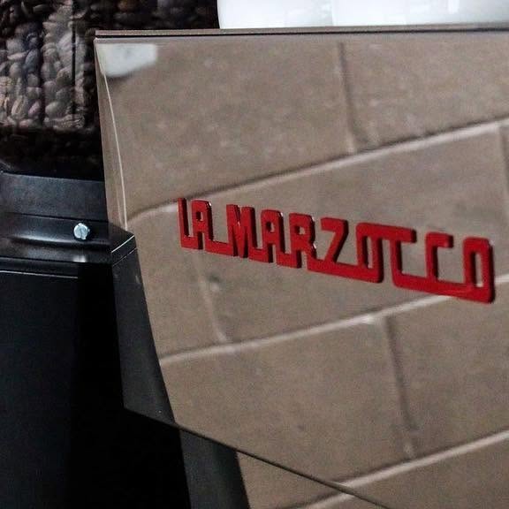 The red La Marzocco lettering on the espresso machine