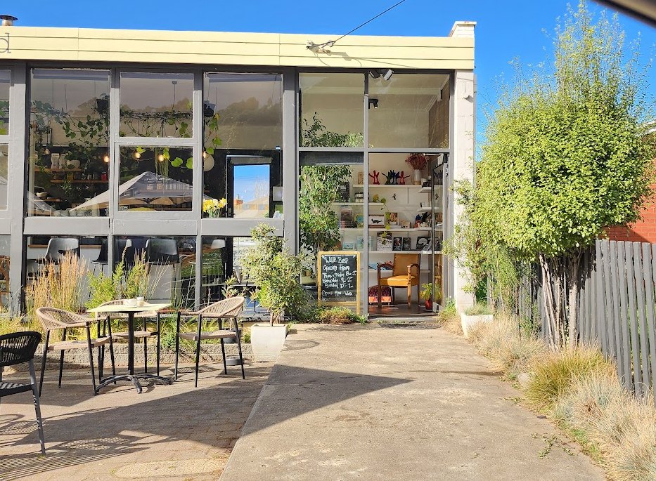 The Wild Bird shopfront in Dover with hanging plants behind the glass and tables out the front
